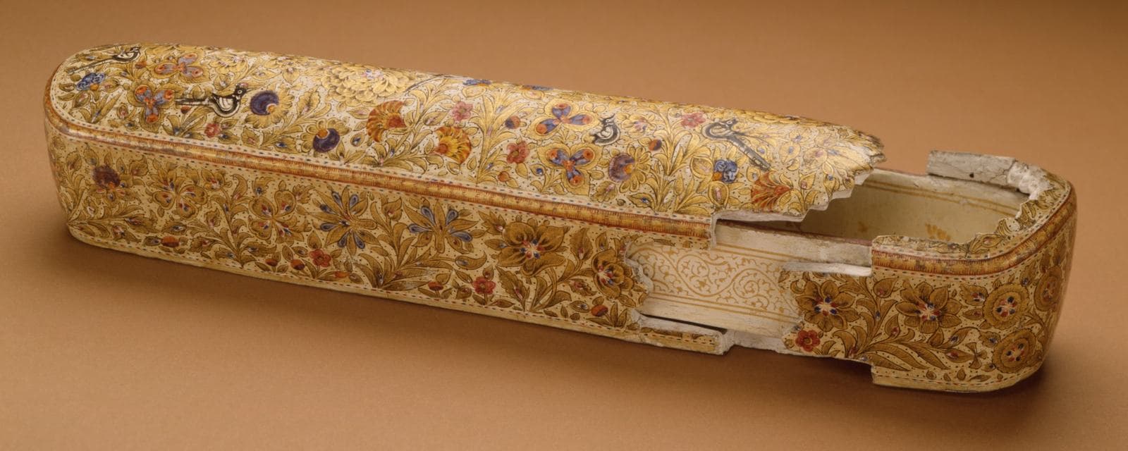 A long painted papier-mâché pen box with floral gold decoration